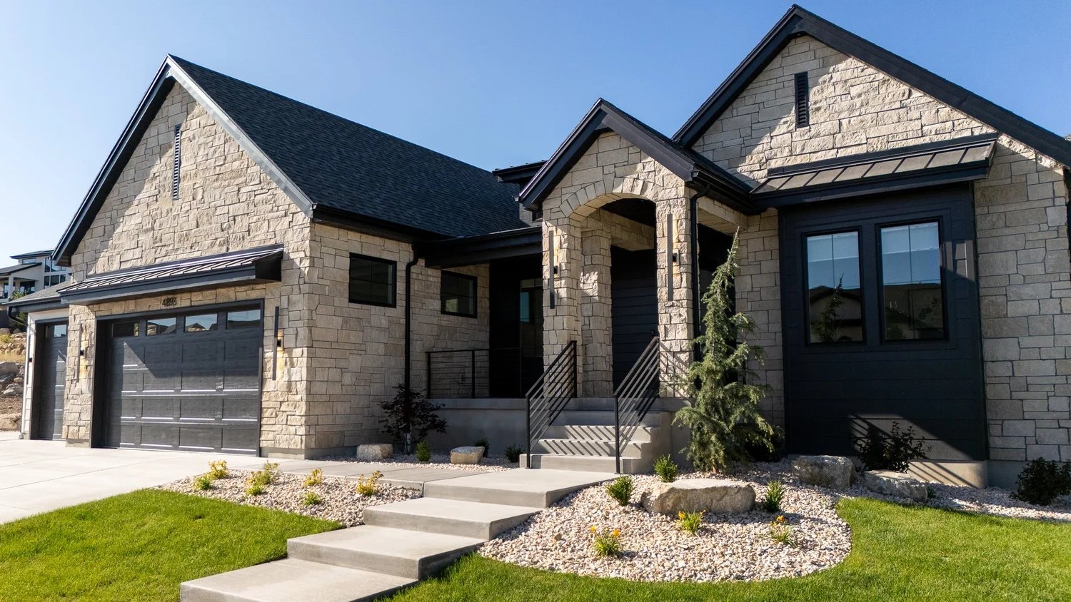 Custom home with natural stone facade and black accents