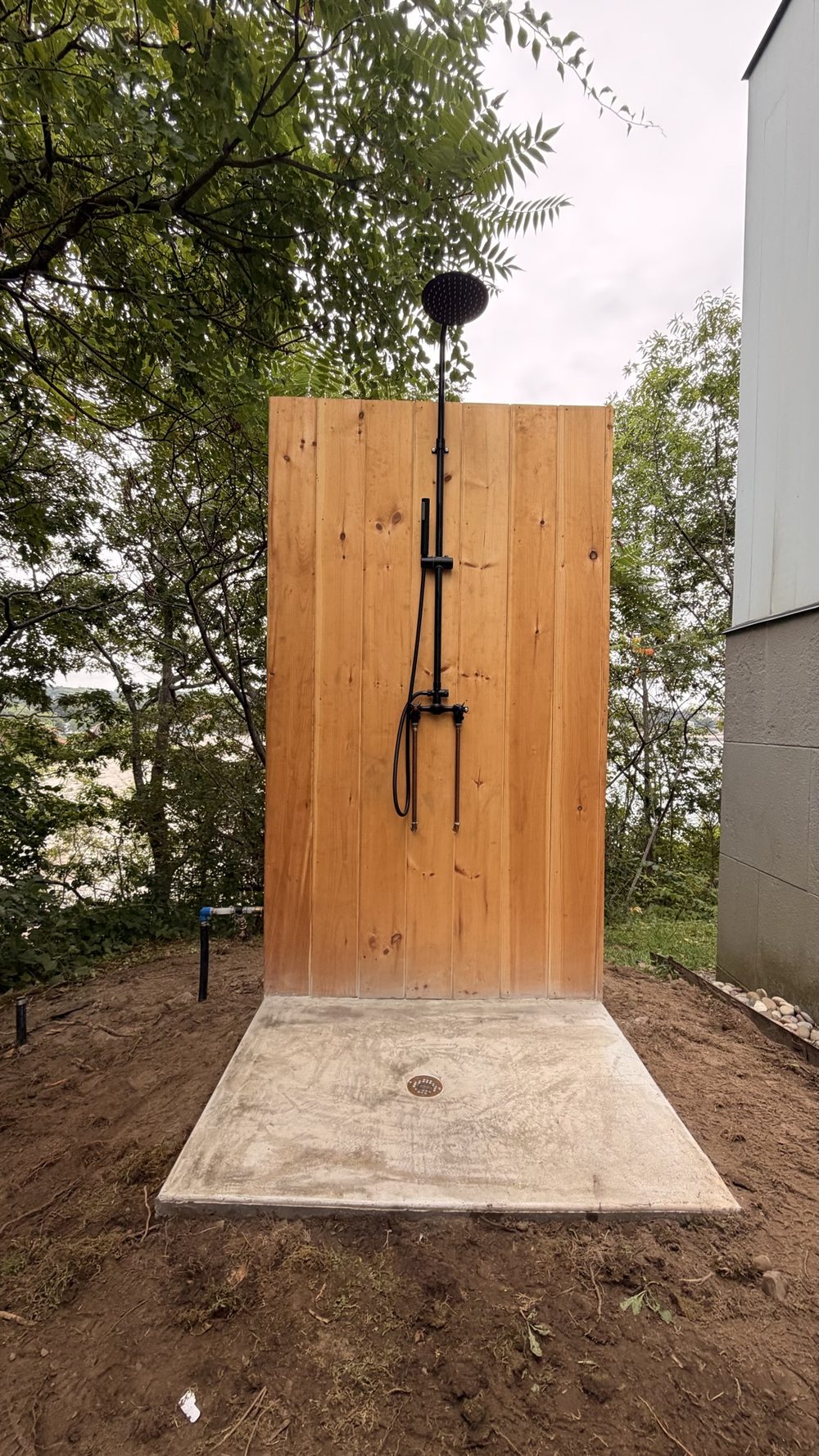 Finished outdoor shower with black rainfall fixture