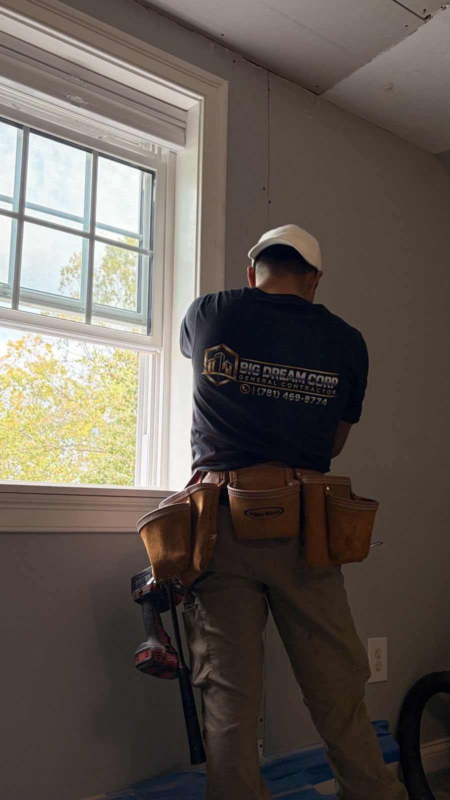 Big Dream Corp crew member in a company shirt installing a window